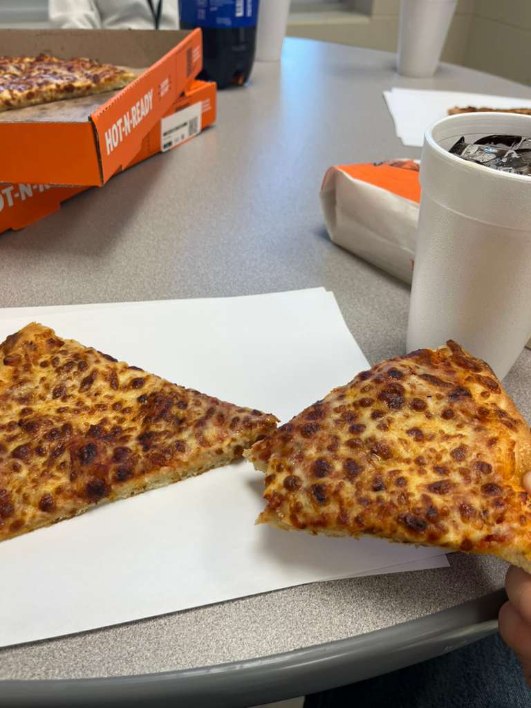 Pizza sitting on pieces of printer paper.